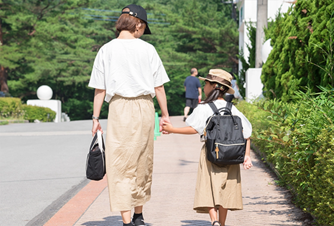 女性と子供が手をつないでいる画像
